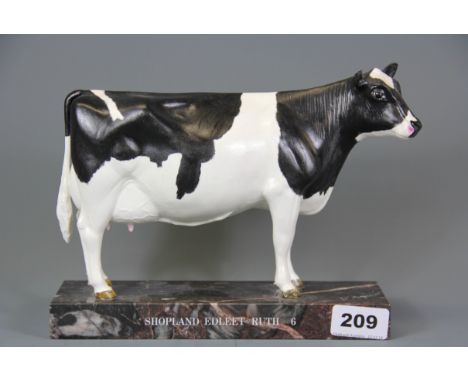 A ceramic presentation figure of a cow on a marble base, signed D'Aquino, H. 418cm, L. 24cm.