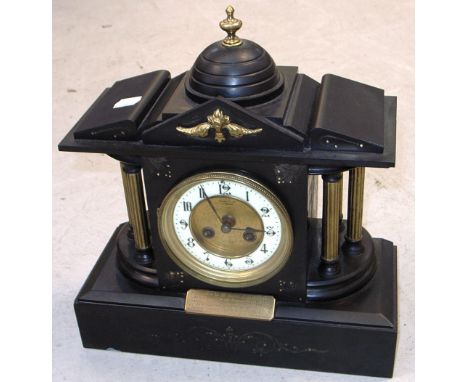 An early 20th century eight day slate mantel clock with enamelled dial set with Arabic numerals flanked by gilt heightened co