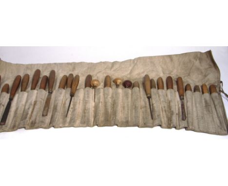 A canvas roll containing a large quantity of chisels and various tools for sculpture.
