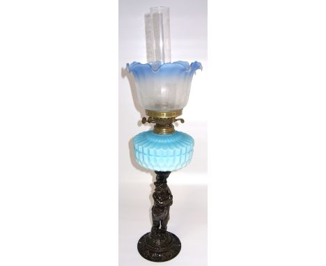 An oil lamp with attractive opaque turquoise reservoir, the support formed from a cherubic like figure, height 73cm.