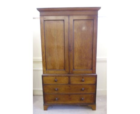 An early Victorian mahogany linen press, having a moulded cornice over a pair of panelled doors, enclosing three shelves, abo