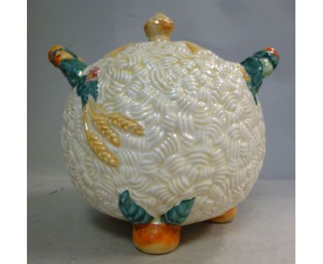 A Clarice Cliff china biscuit jar of bulbous form with opposing loop handles and a hay stook knop on the cover, decorated in 