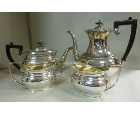 A four piece silver tea set of oval ogee form with gadrooned border ornament  comprising a teapot with ebonised handle and kn