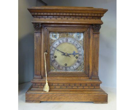 An Edwardian oak cased bracket clock, having a pagoda top, bevelled glass flank panels and the same on the front door, betwee