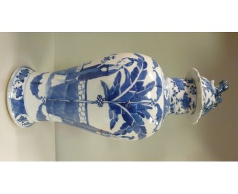 A late 19thC Chinese porcelain temple vase of baluster form, a mythical dog on the domed cover, decorated in blue and white w