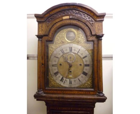 A mid 18thC walnut and marquetry longcase clock, the hood having an arched top, a blind fret carved frieze and turned pillars