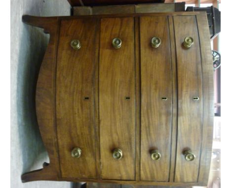 An early 19thC mahogany bow front dressing chest, the top with a satinwood string inlaid border, over four graduated long dra