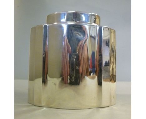 A silver tea caddy of oval, serpentine outline with straight sides and a cover  Adie Bros  Birmingham 1928