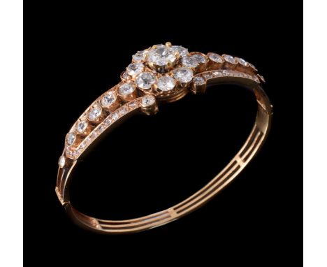 A late 19th century diamond cluster hinged bangle, circa 1890, the central old brilliant cut diamond, estimated to weigh 1.00