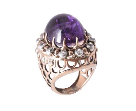 An amethyst and diamond dress ring, the oval cabochon amethyst claw set within a surround of old cut diamonds, in a pierced s