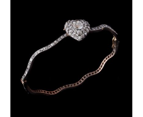 A late 19th century diamond bangle, circa 1890, the heart shaped panel centrally set with an old cushion cut diamond, estimat
