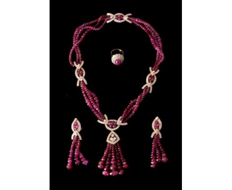 A suite of ruby and diamond jewellery, comprising necklace, ring and ear pendants, the necklace designed with three rows of g