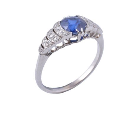 A sapphire and diamond ring, first half 20th century, the cushion shaped mixed cut sapphire claw set above graduated stepped 