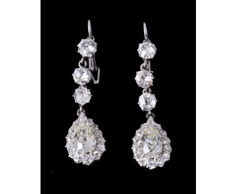 A pair of early twentieth century diamond ear pendants, each drop with an old pear cut diamond within a cluster surround of o