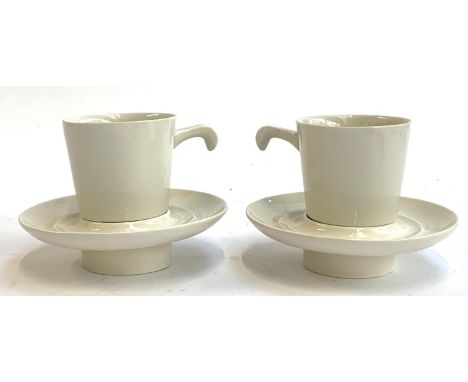 A pair of unusual ceramic coffee cups and saucers with rounded spiked bases 