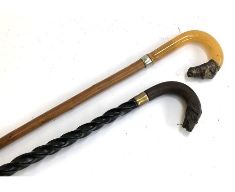 A spiral turned walking stick with hound terminal; together with one other with faux horn and hound terminal 