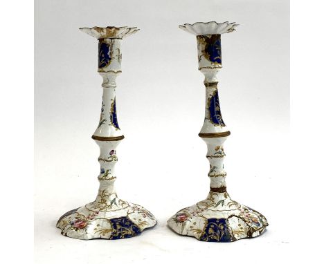 A pair of 18th century South Staffordshire, likely Bilston, enamel candlesticks (af), decorated in blue and white enamel with