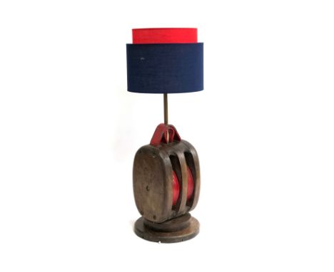 A vintage rope pulley converted for use as an electrical lamp with red and blue shade, 69cmH 