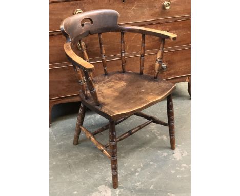 An early 20th century captains chair, the collar with pierced handle, on turned spindles and plain ring turned legs and doubl