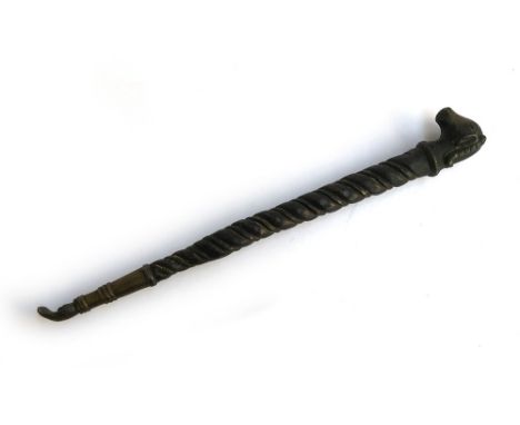 An Indian ceremonial brass mace (Soonta), with ram's head finial, the body of twisted tapering form, terminating in a hand, 4