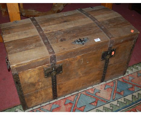 A planked pine, leather strapped and metal mounted hinge-top travelling trunk 