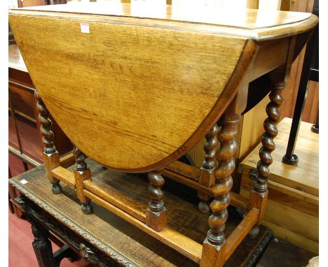 An early 20th century oak barley twist drop leaf dining table, having a gate leg action, width 92cm