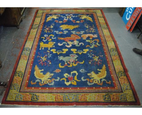 An antique Chinese Peking carpet, the blue ground with Buddhist symbols in colours within a multi-coloured border, 300 x 200 