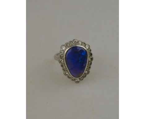 A pear-shaped black opal cabochon and diamond cluster ring, white metal set stamped 18ct Condition Report Opal showing small 