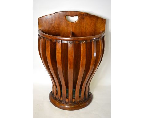 An unusual walnut stick stand of demi-lune form with shaped slat body to a zinc drip tray, 53 cm x 75 cm high