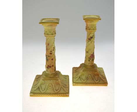 A pair of Victorian Royal Worcester blush ground square based candlesticks painted with flowers, shape 1050, date cypher 1896