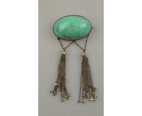 An Arts & Crafts green stone cabochon brooch having two suspended tassels with river pearl terminations, stone approx 35 mm w