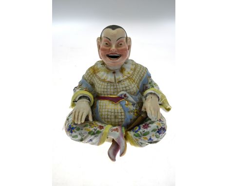 A Meissen 'nodding Chinaman' with hinged head and hands, open grinning mouth, sitting cross-legged in a fantasy floral painte
