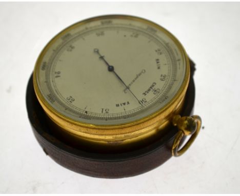 A 19th century gilt brass pocket barometer with silvered dial and revolving bezel, 7 cm diameter, in leather-bound outer case