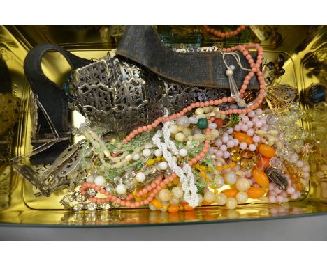 A large collection of vintage jewellery including silver plated belts and buckles, various bead necklaces, brooches, earrings