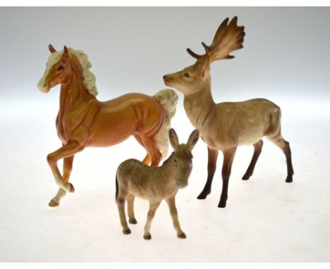 A Beswick Palamino pony, fallow deer, two small bay horses and a donkey foal, to/w a Royal Doulton horse 'Spirit of Fire' and