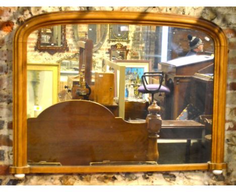A Victorian satinwood framed arched overmantel raised on ceramic feet, 115 cm wide x 86 cm high