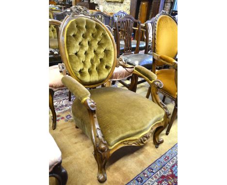 A Victorian carved and moulded walnut framed salon open armchair with button back over an over-stuffed serpentine seat, raise