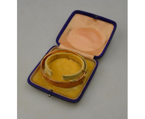 A 9ct yellow gold half engraved bangle approx 12g (bruised) in fitted box