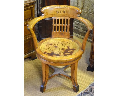 An antique oak swivel armchair, the back carved with 'G E R' for Great Eastern Railway