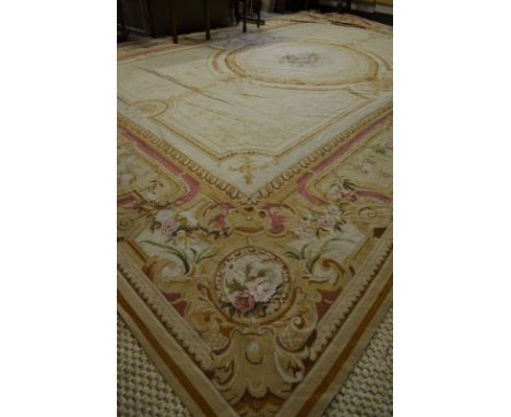 A large wool Aubusson carpet of traditional design executed in pale gold/yellow, ochre and rose, 370 cm x 270 cm Condition Re