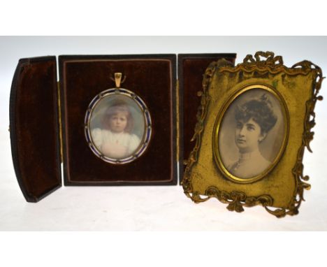 An oval portrait miniature on ivory of a young girl, signed with monogram VC, in gilt metal and enamel frame set with diamond