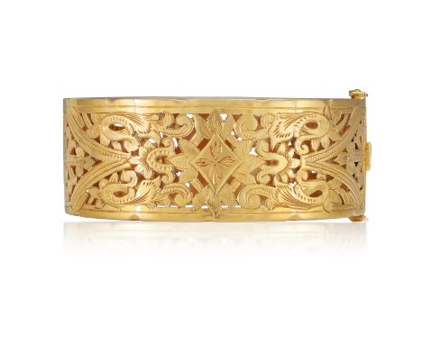 A GOLD CUFF BRACELET, FIRST HALF OF 20TH CENTURY, FRENCH  Of openwork design, the hinged bangle with foliate decorations thro