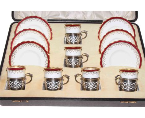 A set of six Wedgwood coffee cans and saucers, each cup in pierced silver holder, Sheffield 1924 by Walker &amp; Hall, cased.