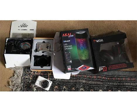 A selection of Tech equipment, headphones, Led dancing speaker, cameras and a webcam.