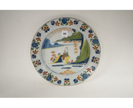 A Lambeth Delftware polychrome dish, decorated in blue, green, red, ochre and iron-red, with a Chinaman in stylised landscape