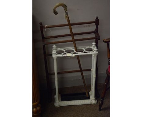 A white painted cast iron stick stand; a stick with fish pattern carved fish handle; and a towel airer.