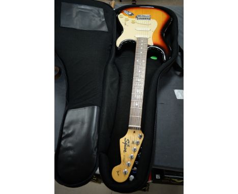 A Squire by Fender Stratocaster style electric guitar, finished in tobacco sunburst, in a Boston soft case.