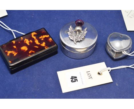 A silver heart-shaped box; a white metal trinket box with thistle decoration; and another trinket box with tortoiseshell deco