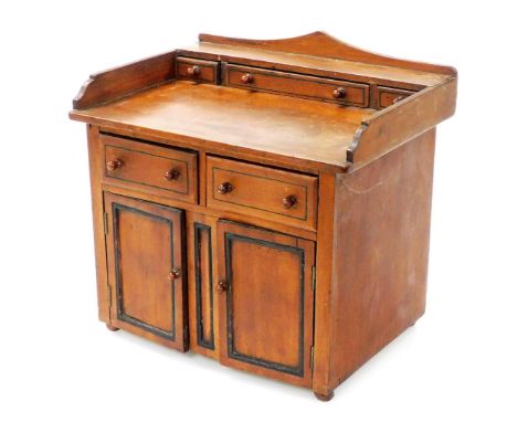 A late Victorian mahogany model dresser, with shallow drawers to the gallery top, two drawers below and cupboard enclosed by 