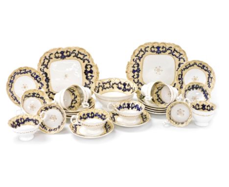 An early 19thC English porcelain tea service, decorated with blue and gilt scroll decoration, on cream borders and comprising